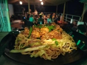 a plate of spaghetti with shrimp on top of it at Dreamcatcher House & Hostel at Arambol Beach in Arambol