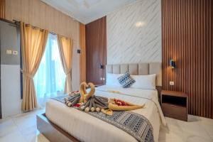 a bedroom with a large bed with towels on it at Wana Kubu Homestay in Kuta +117 photos