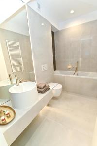 a bathroom with a sink and a toilet and a tub at Cortina Nord Panoramic Studio in Voluntari +8 photos