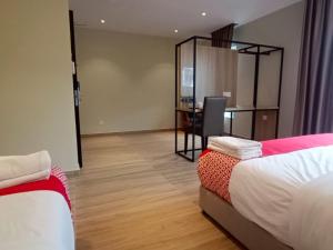 a room with two beds and a desk with a chair at HP Hope Hotel in Johor Bahru
