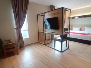 a hotel room with a television and a bed at HP Hope Hotel in Johor Bahru