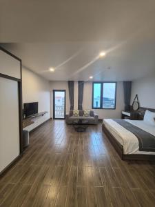 a large bedroom with a bed and a couch at LS HOTEl in Kim Bảng