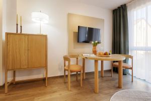 a room with a table and chairs and a tv at homie stay am ring - kostenlose Tiefgarage in Würzburg