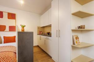 a small bedroom with white cabinets and a bed at homie stay am ring - kostenlose Tiefgarage in Würzburg