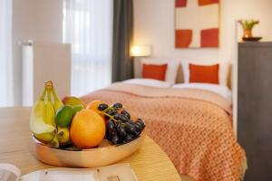 a bowl of fruit on a table in a bedroom at homie stay am ring - kostenlose Tiefgarage in Würzburg +25 photos