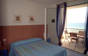 a bedroom with a bed and a balcony with the ocean at Etruriamare in San Vincenzo
