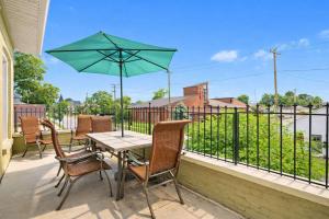 a table and chairs with an umbrella on a balcony at Walkable Historic District Riverview Escape in Jeffersonville