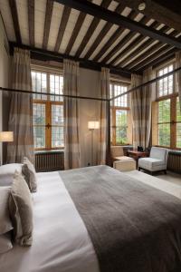 a bedroom with a large bed in a room with windows at Martin's Klooster in Leuven +94 photos