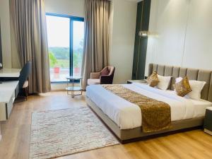 a hotel room with a bed and a desk and a window at The Holy Awadh Hotel in Ayodhya +114 photos