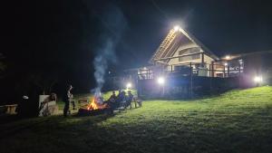 a group of people sitting around a fire at night at Rocky Valley Lakehouse in Pietermaritzburg