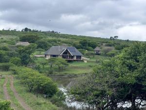 a house on a hill next to a river at Rocky Valley Lakehouse in Pietermaritzburg