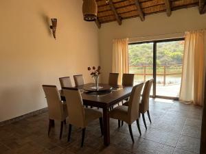 a dining room with a table and chairs and a window at Rocky Valley Lakehouse in Pietermaritzburg