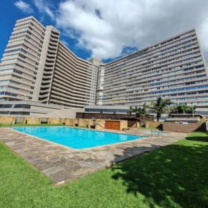 a large hotel with a swimming pool in front of it at Modern Beach View in Kingsborough