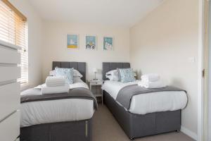 two beds in a small room with white walls at Avalon - Walking Distance to Poole Quay and Town in Poole