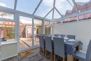 a dining room with a table and chairs and windows at Avalon - Walking Distance to Poole Quay and Town in Poole