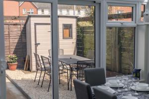 a patio with a table and chairs and a shed at Avalon - Walking Distance to Poole Quay and Town in Poole +36 photos
