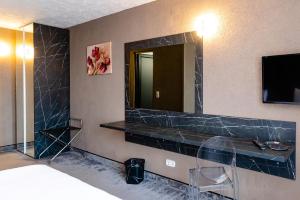 a hotel room with a mirror and a bed at Hotel Ciao in Târgu-Mureş +30 photos