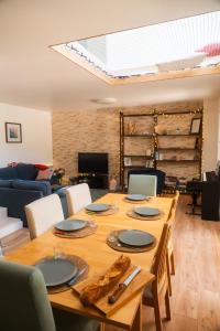 a dining room with a wooden table and a living room at Le Cocon du Golf in Nîmes