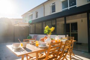 a wooden table with food and drinks on a patio at Le Cocon du Golf in Nîmes