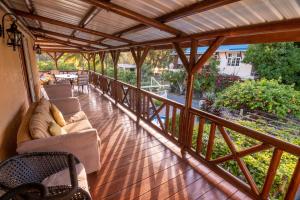 a porch with couches and chairs on a wooden deck at Le Benitier in Port Mathurin