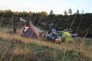 eine Ansammlung von Zelten und ein Lastwagen auf einem Feld in der Unterkunft Arrow aventure in Saint-Étienne-de-Villeréal