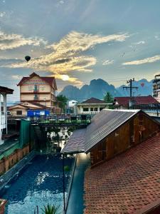 a building with a pool of water in a city at Win Hotel Vang Vieng in Vang Vieng