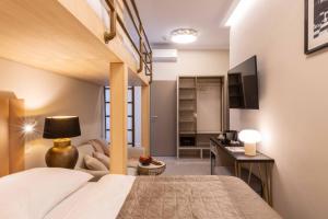 a bedroom with a bed and a desk and a television at PAPPAS hotel&studio in Poděbrady
