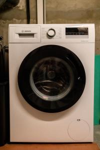a white washing machine with a black door at Le Cocon du Golf in Nîmes