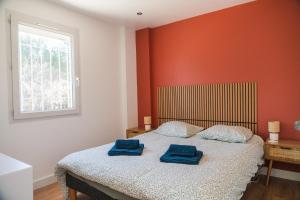 a bedroom with a bed with two blue towels on it at Le Cocon du Golf in Nîmes