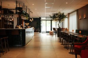 a restaurant with a bar and tables and chairs at Bø Hotel in Bø