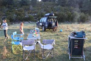 Ein Tisch, Stühle und ein Jeep, die auf einem Feld geparkt sind in der Unterkunft Arrow aventure in Saint-Étienne-de-Villeréal