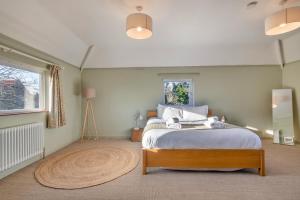 a bedroom with a bed and a large window at Finest Retreats - The Old Windmill in Hindolveston