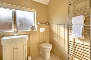 a bathroom with a toilet and a sink and a window at Finest Retreats - The Old Windmill in Hindolveston +20 photos
