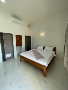a bedroom with a bed in a white room at NIRAN Hotel & Residence in Ban Talai