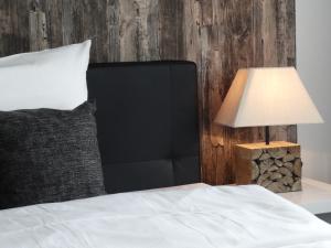 a bed with a black headboard next to a lamp at Hotel Stay in Essen