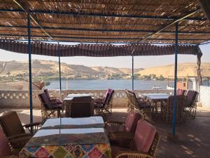 a restaurant with tables and chairs and a view of the water at Labib Guest house in Aswan