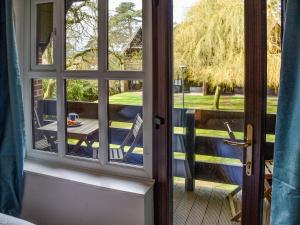 an open door to a patio with a table and chairs at Bittern Lodge in Cromer