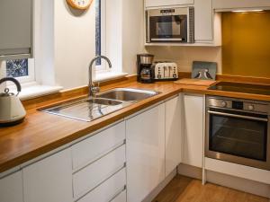 a kitchen with a sink and a microwave at Bittern Lodge in Cromer +24 photos