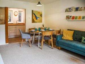 a living room with a table and a blue couch at Bittern Lodge in Cromer