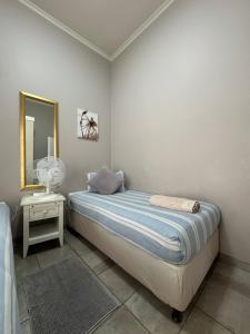 a bedroom with a bed with a mirror and a table at 69 Portobelo in Mossel Bay +79 photos