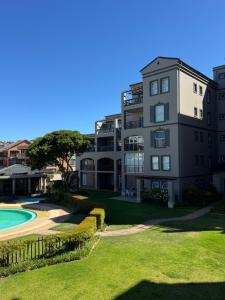 an apartment building with a yard and a pool at 69 Portobelo in Mossel Bay