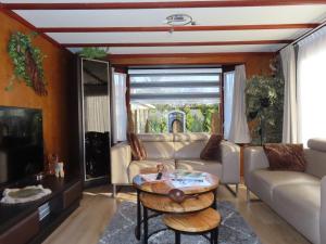 a living room with a couch and a table at Veluwe Park Reewold Chalet Vision in Putten