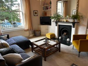 a living room with a blue couch and a fireplace at Southcot Place, Apartment With Garden in Bath
