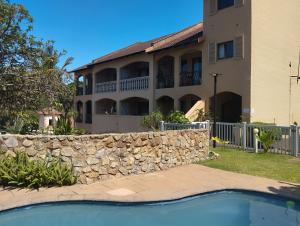 a building with a stone wall and a swimming pool at Crayfish Inn no.8 in Ramsgate