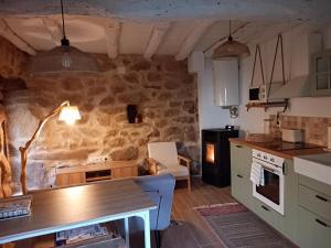 eine Küche mit einem Tisch und einer Steinwand in der Unterkunft Casa Media Lúa in Allariz
