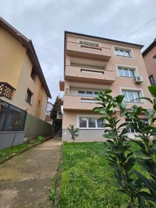 a tall building with a yard next to it at Studio49apartments Quiet in Niš Free Private Parking Fast WiFi in Niš