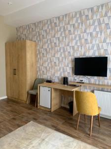 a room with a desk and a tv on a wall at Seven Rooms Hotel in Tbilisi City +19 photos
