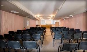 Im Hintergrund ein leerer Raum mit Stühlen und einem Rednerpult in der Unterkunft Alliance Hotel in Plowdiw