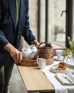 a person standing at a table with a tea set at Antico Convento Dei Cappuccini in Ragusa
