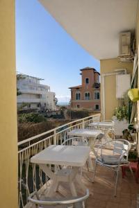 a balcony with tables and chairs on a building at Le VELE in Lido di Ostia